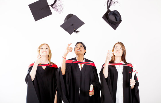 group of female graduates throwing graduation cap