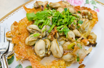 fried oyster with egg and vegetable in dish