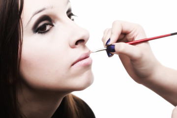 beautiful young woman applying lips make-up zone