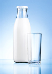Bottle of fresh milk and blank glass on a blue background