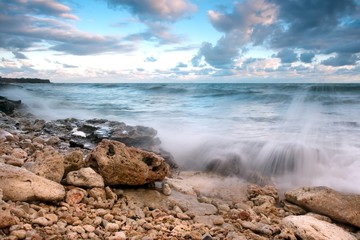 Beautiful rocky sea beach at the sunset