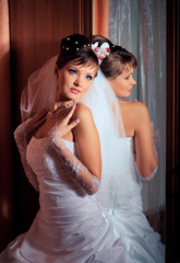 Bride  standing next to the mirror