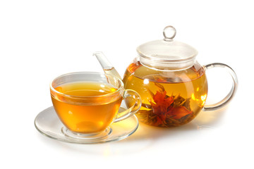 exotic green tea with flowers in glass teapot and cup isolated