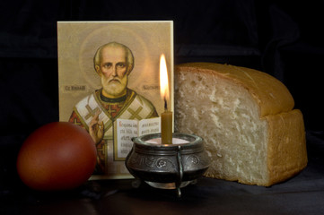 Easter eggs, a burning candle on a black background