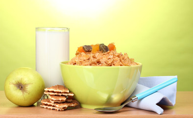 tasty cornflakes in green bowl, apple and glass of milk