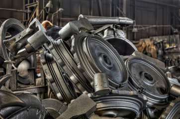 Stack of cast metal parts in a iron foundry - obrazy, fototapety, plakaty
