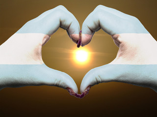Heart and love gesture by hands colored in argentina flag during