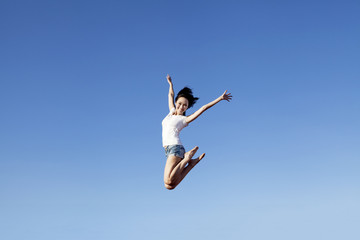 Fototapeta na wymiar Joyful asian woman jumping