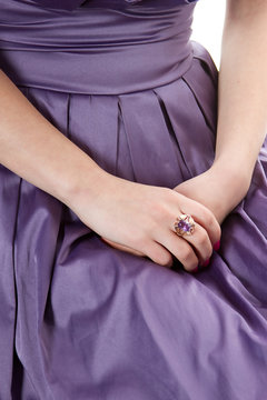 Hands Of A Girl With A Purple Ring On The Dress