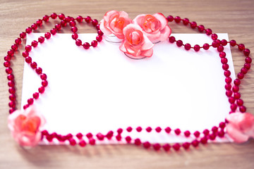 red beaded necklace and pink flower with empty card