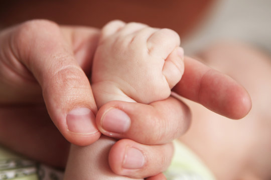 Babyhand in der Hand des Vaters