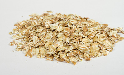 Heap of dry rolled oats isolated on white background