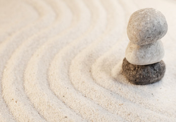 Fototapeta na wymiar galets en équilibre sur stries de sable fin