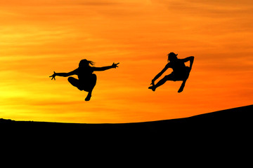 silhouette of friends jumping in sunset for fun