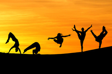 Fototapeta na wymiar silhouette of female gymnasts in sunset