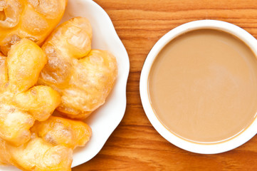 fried dough and coffee on wood background