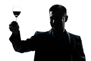 man rising up toasting his glass of red wine