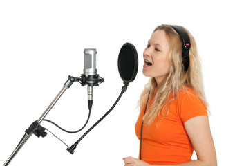 Girl in orange t-shirt singing with studio microphone