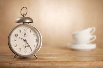 5 o'clock tea time, retro alarm and white tea cups on background