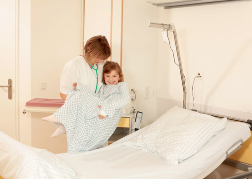 Krankenschwester trägt Kind zum Bett