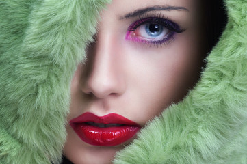 Portrait of young beautiful woman with green fur.