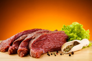 Raw beef on cutting board and vegetables