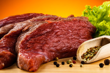 Raw beef on cutting board and vegetables