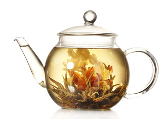 exotic green tea with flowers in glass teapot isolated on white
