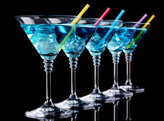Blue cocktail in martini glasses isolated on black