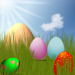 colorful Easter Eggs sitting on grass field with blue sky backgr