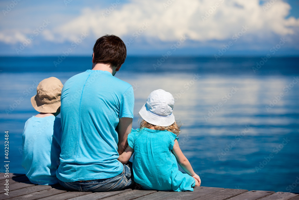 Sticker Father and kids sitting on wooden dock