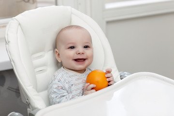 Laughing baby with orange