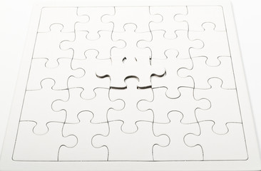 one white jigsaw on jigsaw puzzle pad