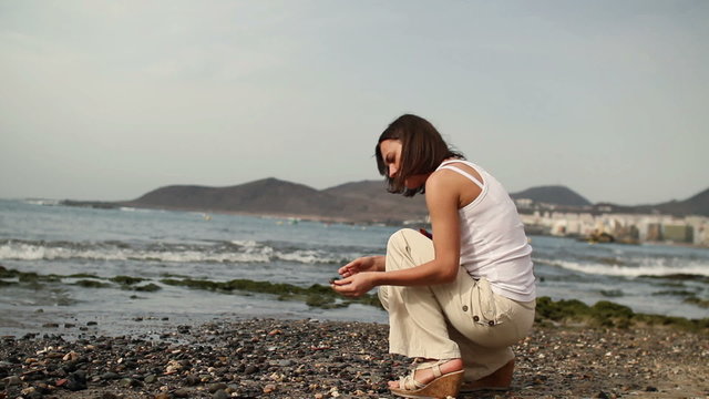 Woman collecting seashells on the beach