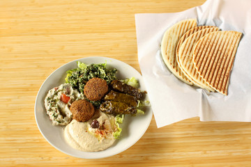 Falafel plate with hummus, baba ganoush, tabouli, and dolmas.