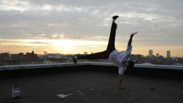 Danseur faisant du break dance sur un toit
