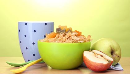 tasty cornflakes in green bowl, apples and glass of milk