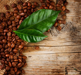 Obraz na płótnie Canvas Projekt Border Coffee. Fasola i liści na tle drewna