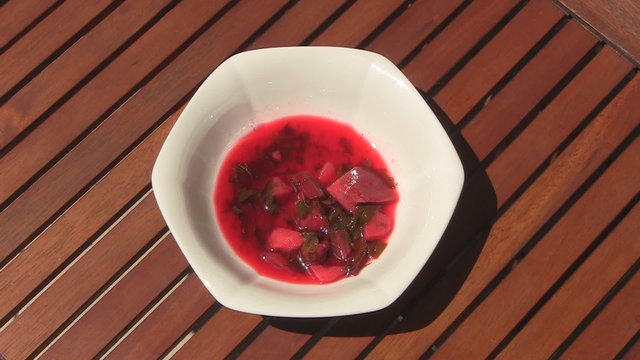 Pouring red borscht into plate