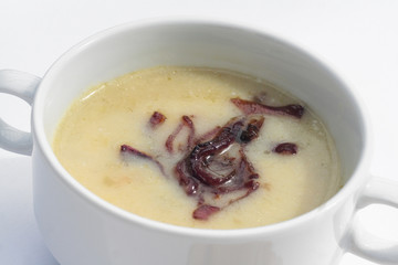 ciotola di minestra di patate con decorazione di cipolle