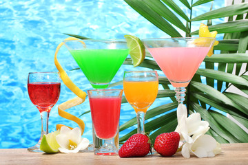 exotic cocktails and flowers on table on blue sea background