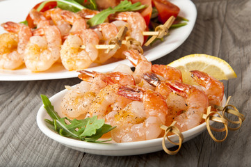 Fresh grilled shrimps with lemon on white plate