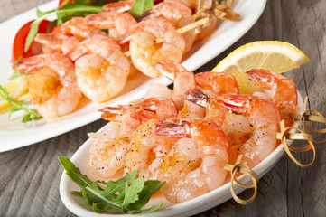 Fresh grilled shrimps with lemon on white plate