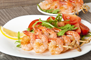 Fresh grilled shrimps with lemon on white plate