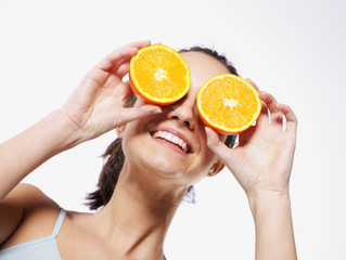 Funny girl portrait, holding oranges over eyes, diet concept