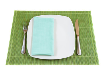 White empty dinner plate with napkin, fork and knife