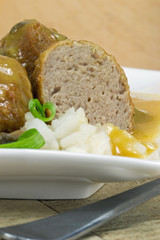 Meat balls in gravy on a white plate