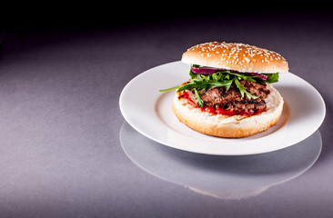 Hamburger with Arugula on Grey Surface