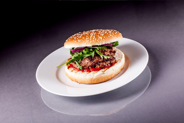 Hamburger with Arugula on Grey Surface