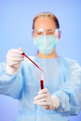 Young woman doctor making blood analysis with test tube and drop